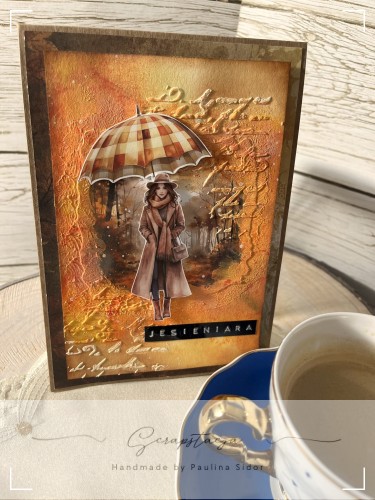 Kartka handmade „Jesieniara” z jesienną ilustracją kobiety z parasolką w ciepłych odcieniach pomarańczu, żółci i czerwieni. Projekt sezonowy od Scrapstacja.