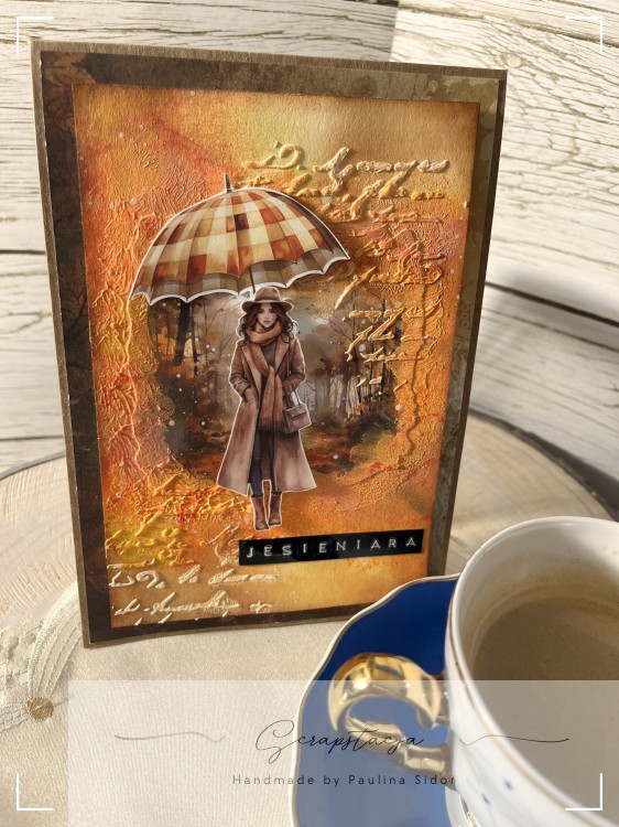 Kartka handmade „Jesieniara” z jesienną ilustracją kobiety z parasolką w ciepłych odcieniach pomarańczu, żółci i czerwieni. Projekt sezonowy od Scrapstacja.