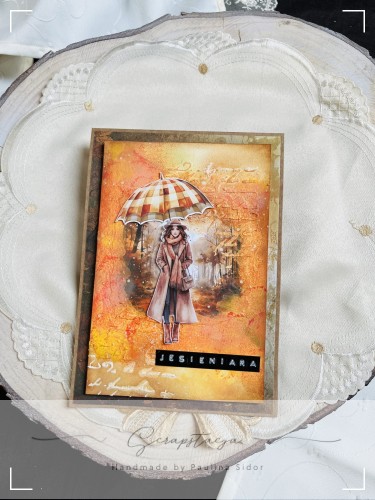 Kartka handmade „Jesieniara” z jesienną ilustracją kobiety z parasolką w ciepłych odcieniach pomarańczu, żółci i czerwieni. Projekt sezonowy od Scrapstacja.