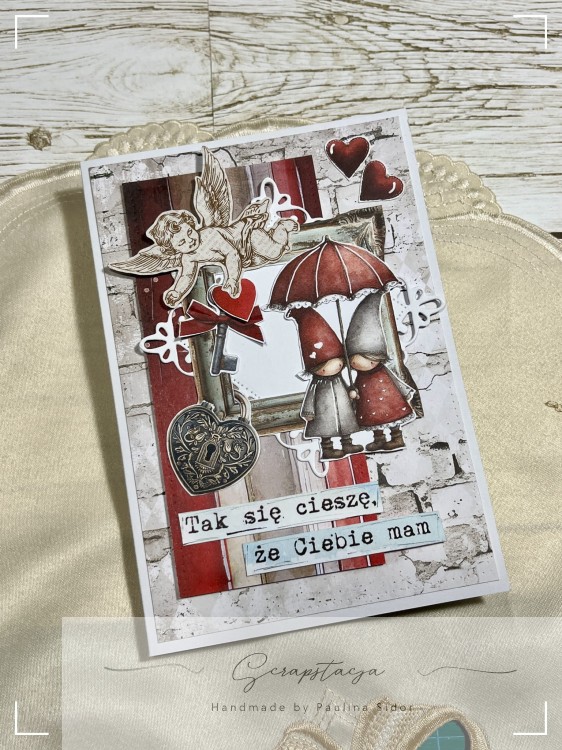 Kartka walentynkowa handmade, scrapbooking, para pod parasolem, czerwone serca, napis „Tak się cieszę, że Ciebie mam”.