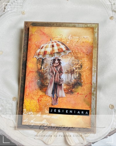Kartka handmade „Jesieniara” z jesienną ilustracją kobiety z parasolką w ciepłych odcieniach pomarańczu, żółci i czerwieni. Projekt sezonowy od Scrapstacja.